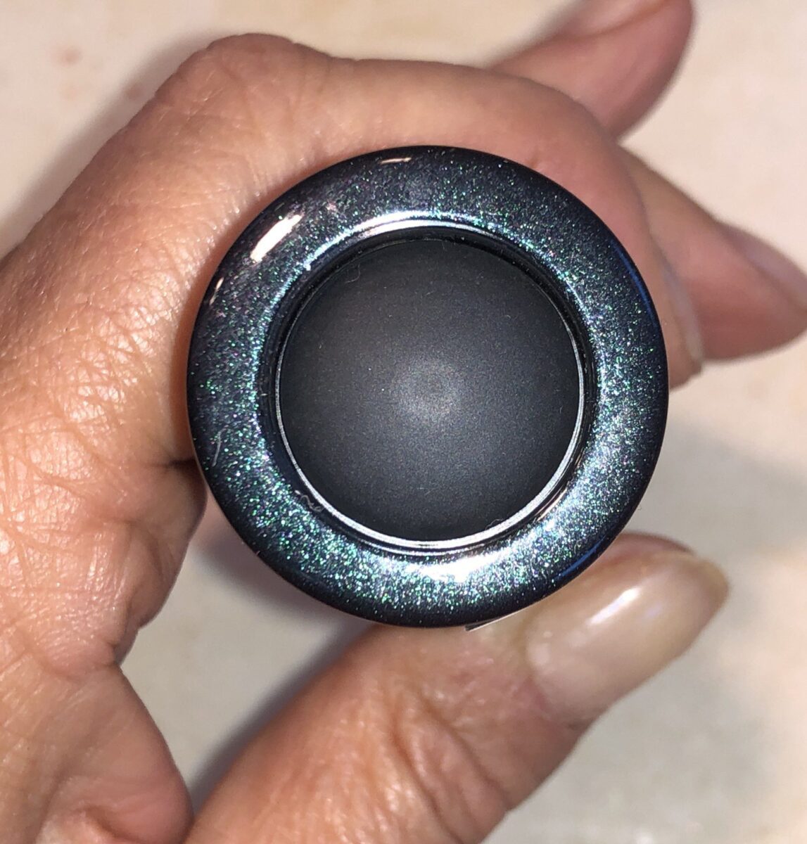PUSH THE BUTTON ON THE BOTTOM OF THE SURRATT DEW DROP FOUNDATION TO DISPENSE A DROP OF FOUNDATION